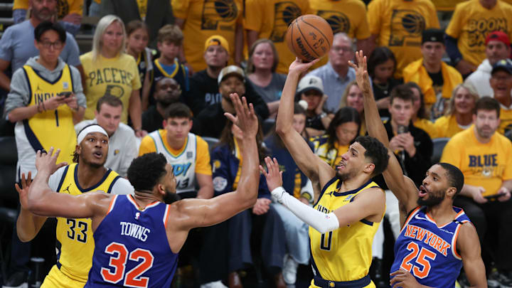 May 31, 2025; Indianapolis, Indiana, USA; Indiana Pacers guard Tyrese Haliburton (0) shoots the ball against New York Knicks center Karl-Anthony Towns (32) and forward Mikal Bridges (25) in the fourth quarter during game six of the eastern conference finals for the 2025 NBA Playoffs at Gainbridge Fieldhouse. Mandatory Credit: Trevor Ruszkowski-Imagn Images