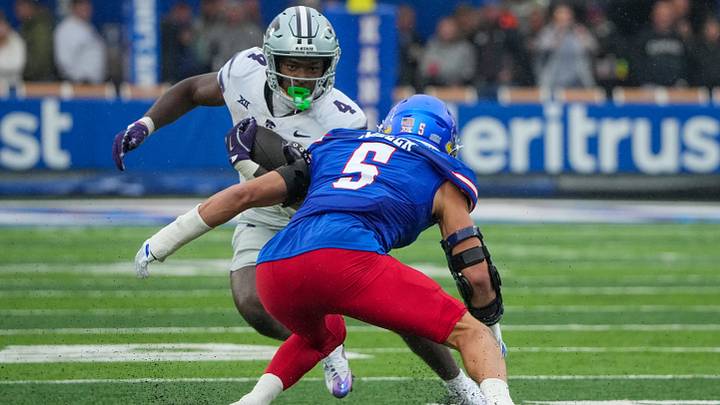 Oct 25, 2025; Lawrence, Kansas, USA; Kansas State Wildcats running back Joe Jackson (4) runs the ball as Kansas Jayhawks defensive end Dean Miller (5) attempts the tackle during the first half of the game at David Booth Kansas Memorial Stadium. Mandatory Credit: Denny Medley-Imagn Images Oct 25, 2025; Lawrence, Kansas, USA; Kansas State Wildcats running back Joe Jackson (4) runs the ball as Kansas Jayhawks defensive end Dean Miller (5) attempts the tackle during the first half of the game at David Booth Kansas Memorial Stadium. Mandatory Credit: Denny Medley-Imagn Images