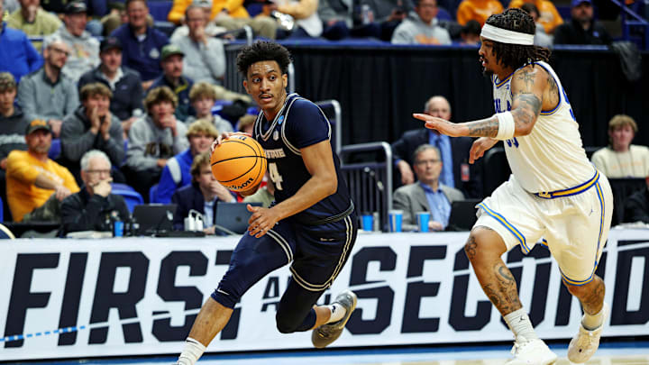 Mar 20, 2025; Lexington, KY, USA;  Utah State Aggies guard Ian Martinez (4) drives to the basket against UCLA Bruins guard Skyy Clark (55) during the second half in the first round of the NCAA Tournament at Rupp Arena. Mandatory Credit: Jordan Prather-Imagn Images