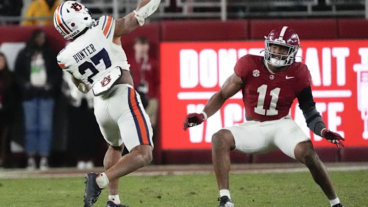 Nov 30, 2024; Tuscaloosa, Alabama, USA;  Auburn Tigers running back Jarquez Hunter (27) throws a pass against Alabama Crimson Tide linebacker Jihaad Campbell (11) during the second half at Bryant-Denny Stadium. The pass was intercepted. Alabama won 28-14. Mandatory Credit: Gary Cosby Jr.-Imagn Images