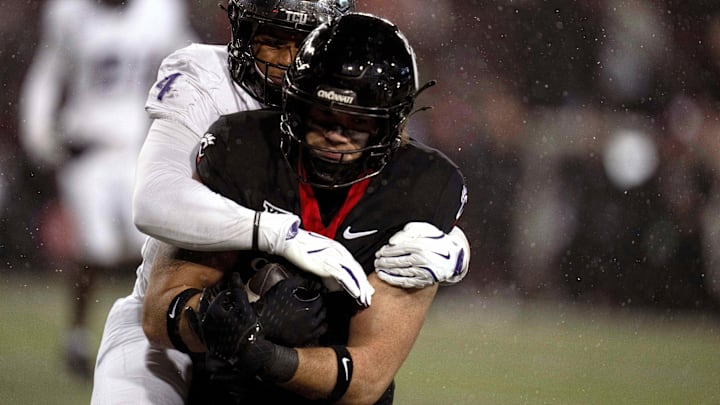 Nov 30, 2024; Cincinnati, Ohio, USA; TCU Horned Frogs linebacker Namdi Obiazor (4) tackles Cincinnati Bearcats tight end Joe Royer (11) in the third quarter at Nippert Stadium. Mandatory Credit: Albert Cesare/USA TODAY Network via Imagn Images