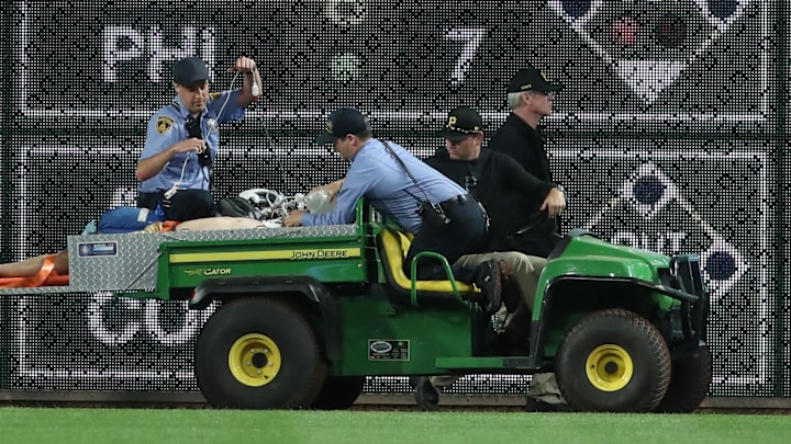 Apr 30, 2025; Pittsburgh, Pennsylvania, USA;  Stadium security and Pittsburgh Pirates medical personnel cart a fan who fell from the stands to the field to an ambulance as the Pirates batted against the Chicago Cubs during the seventh inningat PNC Park. Mandatory Credit: Charles LeClaire-Imagn Images