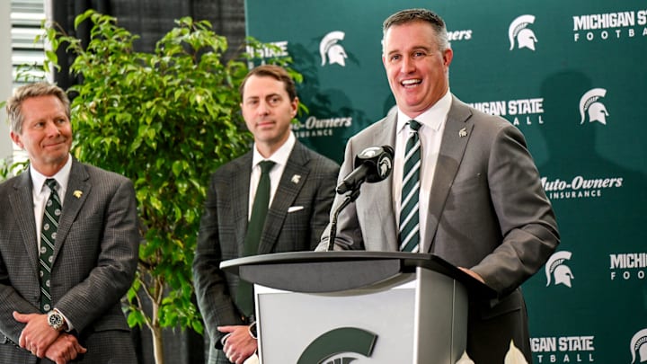 Michigan State's new football coach Pat Fitzgerald, right,, talks during his introductory press conference on Tuesday, Dec. 2, 2025, at the Tom Izzo Football Building in East Lansing. At left, MSU Athletic Director J Batt and MSU President Kevin Guskiewicz, center, look on.