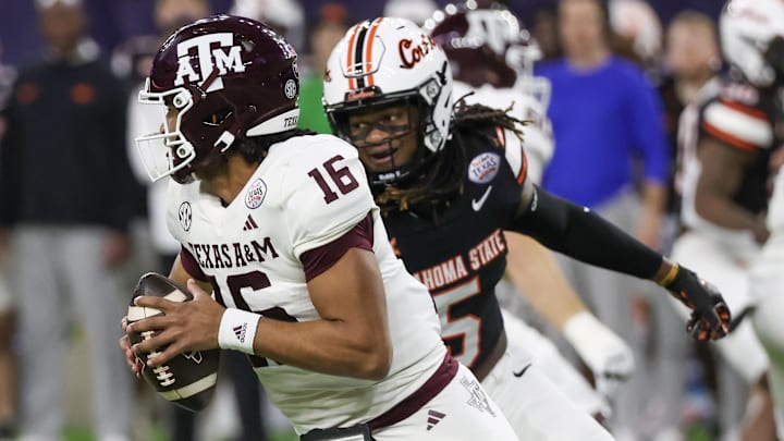 Dec 27, 2023; Houston, TX, USA; Texas A&M Aggies quarterback Jaylen Henderson (16) scrambles from Oklahoma State Cowboys safety Kendal Daniels (5) in the first quarter at NRG Stadium. Henderson was injured on the play and taken out of the game. Mandatory Credit: Thomas Shea-Imagn Images
