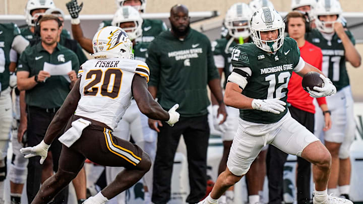 Michigan State tight end Jack Velling (12) makes a catch against Western Michigan defensive end Kershawn Fisher (20) during the first half at Spartan Stadium in East Lansing on Friday, August 29, 2025.