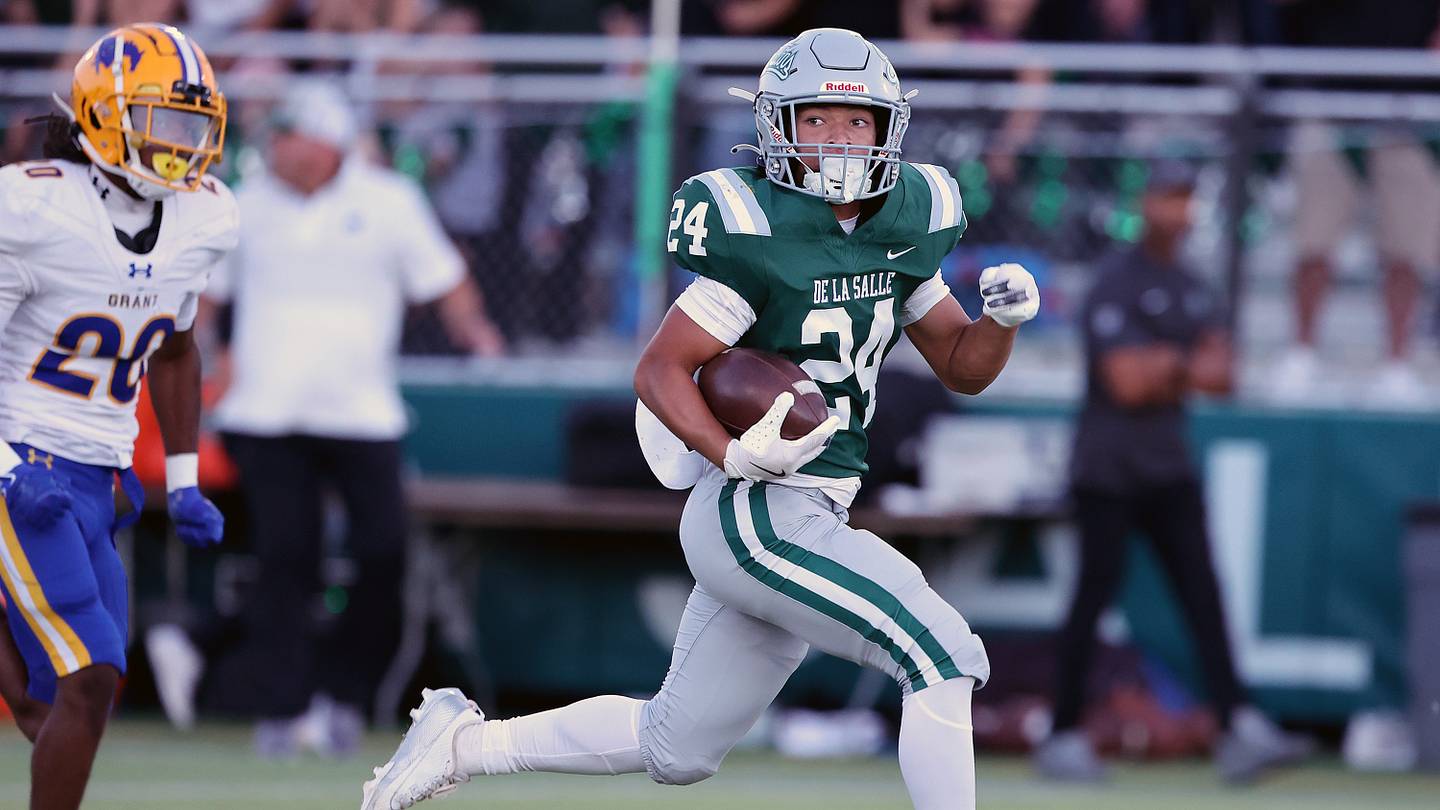 Un running back californiano in azione durante un match di calcio, con un gruppo di spettatori intorno a lui