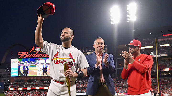 Sep 30, 2022; St. Louis, Missouri, USA; (L-R) St. Louis Cardinals designated hitter Albert Pujols (5) waves to fans as president of baseball operations John Mozeliak and manager Oliver Marmol (37) look on during a ceremony to celebrate Albert Pujols 700th career home run before a game against the Pittsburgh Pirates at Busch Stadium. Mandatory Credit: Jeff Curry-Imagn Images Sep 30, 2022; St. Louis, Missouri, USA; (L-R) St. Louis Cardinals designated hitter Albert Pujols (5) waves to fans as president of baseball operations John Mozeliak and manager Oliver Marmol (37) look on during a ceremony to celebrate Albert Pujols 700th career home run before a game against the Pittsburgh Pirates at Busch Stadium. Mandatory Credit: Jeff Curry-Imagn Images