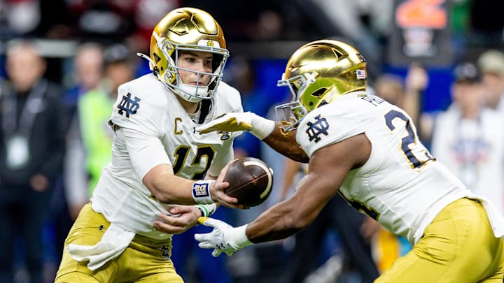 Notre Dame Fighting Irish quarterback Riley Leonard (13) hands off to Notre Dame Fighting Irish running back Jadarian Price (24)