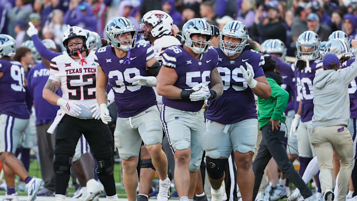 Nov 1, 2025; Manhattan, Kansas, USA; Kansas State Wildcats defensive tackle Damian Ilalio (56), defensive end Travis Bates (39) and defensive tackle Uso Seumalo (99) celebrate a fumble recovery during the fourth quarter against the Texas Tech Red Raiders at Bill Snyder Family Football Stadium. 