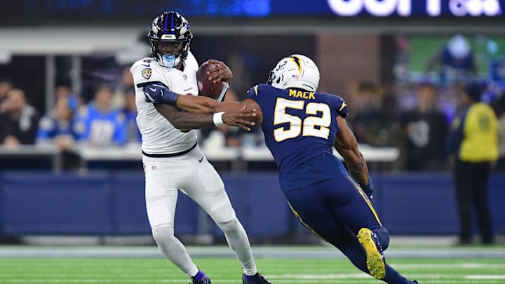 Nov 25, 2024; Inglewood, California, USA; Baltimore Ravens quarterback Lamar Jackson (8) runs the ball against Los Angeles Chargers linebacker Khalil Mack (52) during the second half at SoFi Stadium. Mandatory Credit: Gary A. Vasquez-Imagn Images