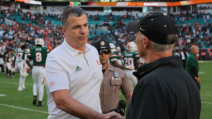 Nov 23, 2024; Miami Gardens, Florida, USA; Miami Hurricanes head coach Mario Cristobal shakes hands with Wake Forest Demon Deacons head coach Dave Clawson after the game at Hard Rock Stadium. Mandatory Credit: Sam Navarro-Imagn Images Nov 23, 2024; Miami Gardens, Florida, USA; Miami Hurricanes head coach Mario Cristobal shakes hands with Wake Forest Demon Deacons head coach Dave Clawson after the game at Hard Rock Stadium. Mandatory Credit: Sam Navarro-Imagn Images