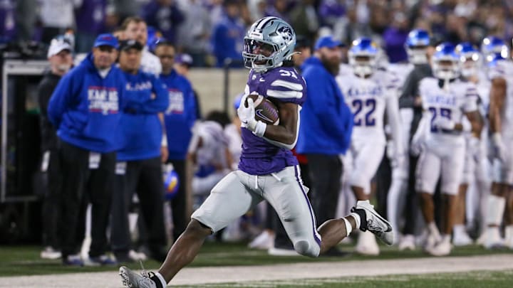 Oct 26, 2024; Manhattan, Kansas, USA; Kansas State Wildcats running back DJ Giddens (31) tries to run from Kansas Jayhawks cornerback Mello Dotson (3) during the fourth quarter at Bill Snyder Family Football Stadium. Mandatory Credit: Scott Sewell-Imagn Images