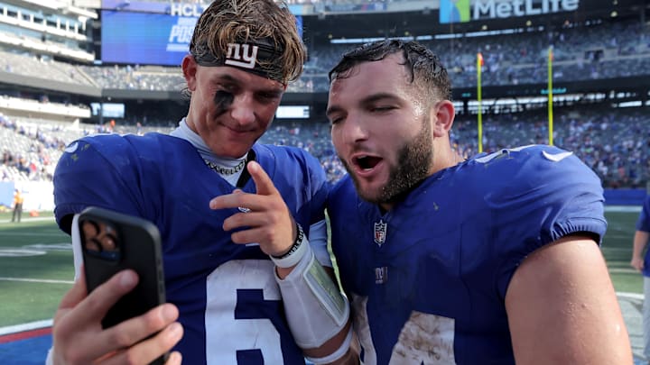 Sep 28, 2025; East Rutherford, New Jersey, USA; New York Giants quarterback Jaxson Dart (6) and running back Cam Skattebo (44) record a video on a smartphone after defeating the Los Angeles Chargers at MetLife Stadium.