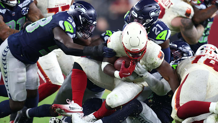 Sep 25, 2025; Glendale, Arizona, USA; Seattle Seahawks cornerback Devon Witherspoon (21) and linebacker Derick Hall (58) tackle Arizona Cardinals running back Trey Benson (33) in the third quarter at State Farm Stadium. Mandatory Credit: Mark J. Rebilas-Imagn Images