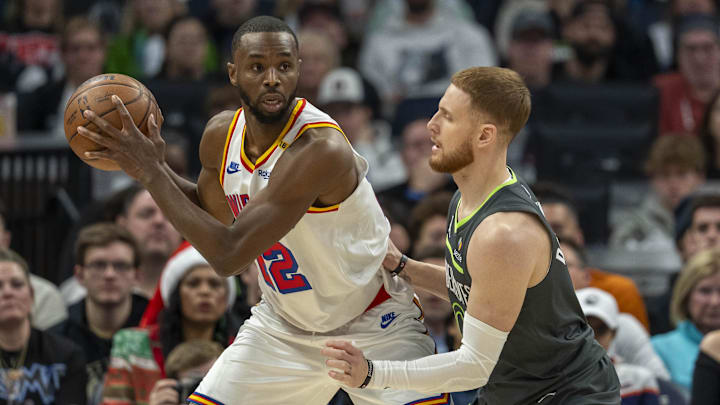 Golden State Warriors forward Andrew Wiggins backs towards the basket as Minnesota Timberwolves guard Donte DiVincenzo plays defense in the first half at Target Center in Minneapolis on Dec. 21, 2024.