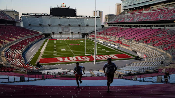 Brutus Buckeye team members Kurt Steelman, left, and Caleb Kies run steps inside Ohio Stadium at the start of an early morning conditioning workout on Aug. 25, 2025.