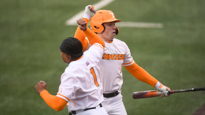 Tennessee infielder Billy Amick (11) is congratulated by teammate Christian Moore (1) after hitting