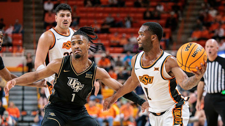 Jan 6, 2026; Stillwater, Oklahoma, USA; Oklahoma State Cowboys guard Kanye Clary (1) passes the ball around UCF Knights guard Themus Fulks (1) during the first half at Gallagher-Iba Arena. Mandatory Credit: William Purnell-Imagn Images Jan 6, 2026; Stillwater, Oklahoma, USA; Oklahoma State Cowboys guard Kanye Clary (1) passes the ball around UCF Knights guard Themus Fulks (1) during the first half at Gallagher-Iba Arena. Mandatory Credit: William Purnell-Imagn Images
