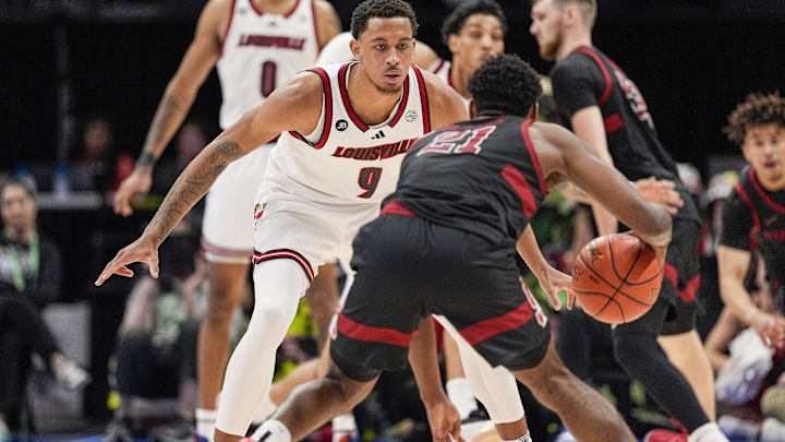 Mar 13, 2025; Charlotte, NC, USA; Louisville Cardinals guard Cole Sherman (4) on defense against Stanford Cardinal guard Jaylen Blakes (21) during the second half at Spectrum Center. Mandatory Credit: Jim Dedmon-Imagn Images