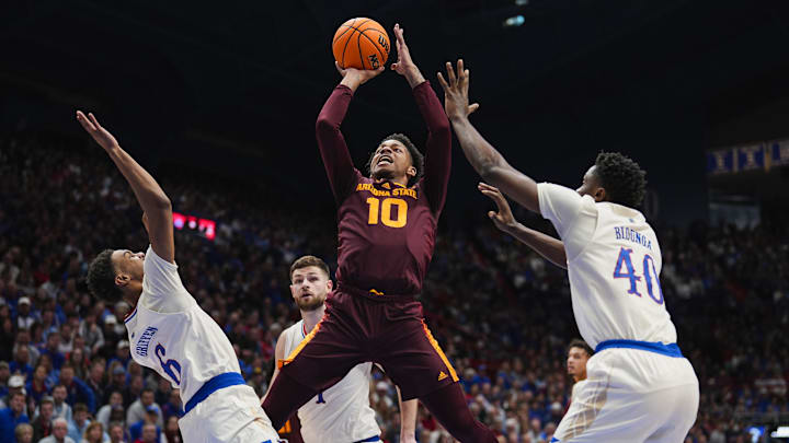 Jan 8, 2025; Lawrence, Kansas, USA; Arizona State Sun Devils guard BJ Freeman (10) shoots against Kansas Jayhawks guard Rylan Griffen (6) and forward Flory Bidunga (40) during the first half at Allen Fieldhouse. Mandatory Credit: Jay Biggerstaff-Imagn Images
