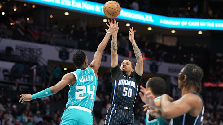 Apr 5, 2024; Charlotte, North Carolina, USA; Orlando Magic guard Cole Anthony (50) shoots a jumper against Charlotte Hornets forward Brandon Miller (24) during the first quarter at Spectrum Center. Mandatory Credit: Jim Dedmon-Imagn Images