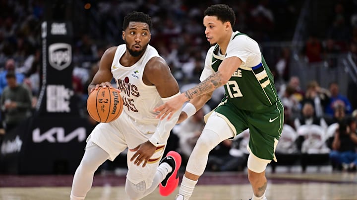 Oct 26, 2025; Cleveland, Ohio, USA; Cleveland Cavaliers guard Donovan Mitchell (45) drives to the basket against Milwaukee Bucks guard Ryan Rollins (13) during the second half at Rocket Arena. Mandatory Credit: Ken Blaze-Imagn Images