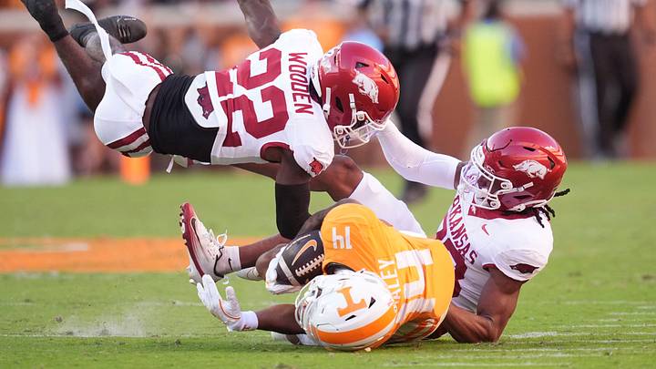 Tennessee wide receiver Braylon Staley (14) is brought down by Arkansas defensive backs Caleb Wooden (22) and Julian Neal (23) in an NCAA college football game on Oct. 11, 2025, in Knoxville, Tennessee.