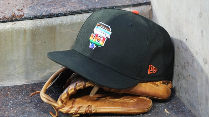 Jun 16, 2023; Los Angeles, California, USA; A rainbow colored San Francisco Giants logo cap and a glove in the dugout during LGBTQ+ Pride Night at Dodger Stadium at Dodger Stadium.