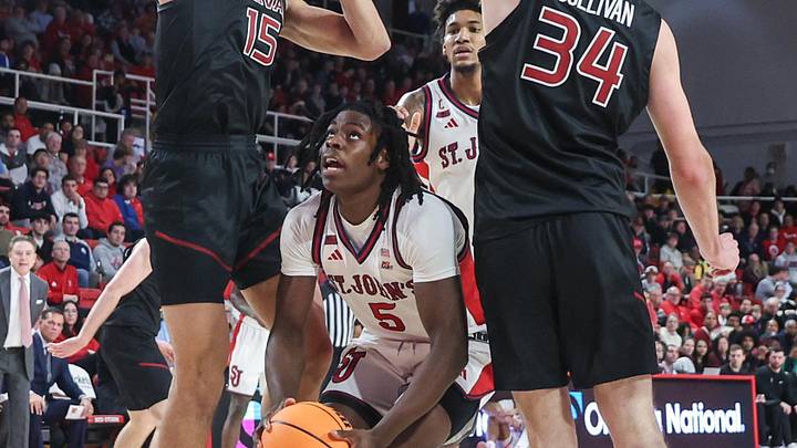 Dec 23, 2025; Queens, New York, USA;  St. John's Red Storm guard Kelvin Odih (5) looks to post up against Harvard Crimson forwards Thomas Batties II (15) and Ryan Sullivan (34) in the second half at Carnesecca Arena.