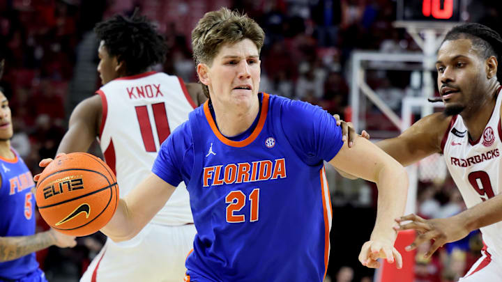 Jan 11, 2025; Fayetteville, Arkansas, USA; Florida Gators forward Alex Condon (21) drives against Arkansas Razorbacks forward Jonas Aidoo (9) in the second half at Bud Walton Arena. Florida won 71-63. Mandatory Credit: Nelson Chenault-Imagn Images