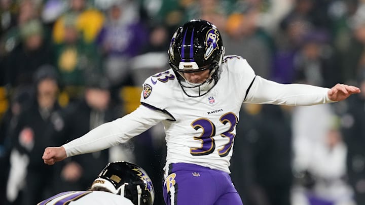 Dec 27, 2025; Green Bay, Wisconsin, USA; Baltimore Ravens place kicker Tyler Loop (33) kicks an extra point out of the hold from Baltimore Ravens punter Jordan Stout (11) during the fourth quarter at Lambeau Field. Mandatory Credit: Kayla Wolf-Imagn Images