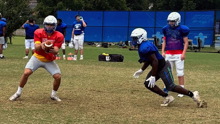 Winston Churchill football players work on the handoff exchange during a 2025 training camp practice.
