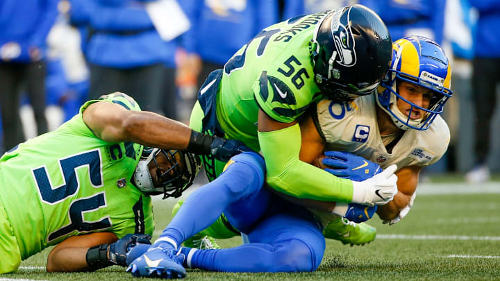 Oct 7, 2021; Seattle, Washington, USA; Los Angeles Rams wide receiver Cooper Kupp (10) is tackled by Seattle Seahawks middle linebacker Bobby Wagner (54) and linebacker Jordyn Brooks (56) after making a reception during the first quarter at Lumen Field.