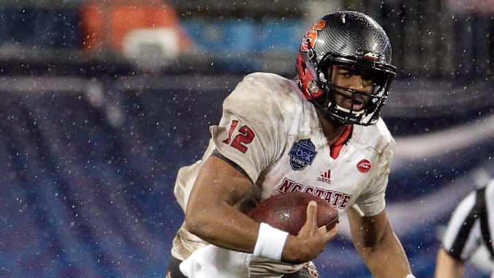 Dec 30, 2015; Charlotte, NC, USA; North Carolina State Wolfpack quarterback Jacoby Brissett (12) runs the ball during the third quarter against the Mississippi State Bulldogs in the 2015 Belk Bowl at Bank of America Stadium. The Bulldogs defeated the Wolfpack 51-28. Mandatory Credit: Jeremy Brevard-Imagn Images