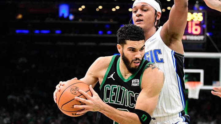 Dec 15, 2023; Boston, Massachusetts, USA: Boston Celtics forward Jayson Tatum (0) drives the ball  against Orlando Magic forward Paolo Banchero (5) during the second half at TD Garden. Mandatory Credit: Eric Canha-Imagn Images