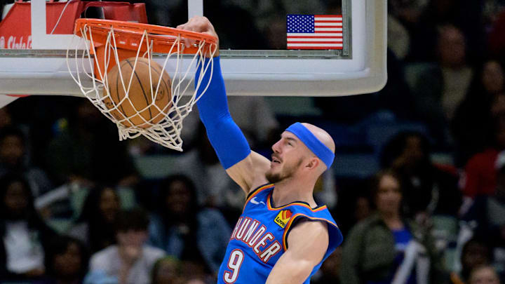 Dec 7, 2024; New Orleans, Louisiana, USA; Oklahoma City Thunder guard Alex Caruso (9) dunks against New Orleans Pelicans guard Dejounte Murray (5) during the second half at Smoothie King Center. Mandatory Credit: Matthew Hinton-Imagn Images