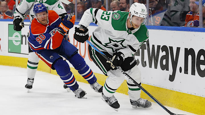 May 29, 2024; Edmonton, Alberta, CAN; Dallas Stars defensemen Esa Lindell (23) moves the puck in front of Edmonton Oilers forward Corey Perry (90) during the first period in game four of the Western Conference Final of the 2024 Stanley Cup Playoffs at Rogers Place. Mandatory Credit: Perry Nelson-Imagn Images