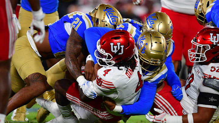 Aug 30, 2025; Pasadena, California, USA;  Utah Utes quarterback Devon Dampier (4) is brought down by the against the UCLA Bruins defense during the first half at the Rose Bowl. Mandatory Credit: Gary A. Vasquez-Imagn Images