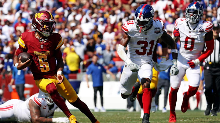 Sep 15, 2024; Landover, Maryland, USA; Washington Commanders quarterback Jayden Daniels (5) runs the ball against New York Giants safety Tyler Nubin (31) during the second quarter at Commanders Field. Mandatory Credit: Peter Casey-Imagn Images