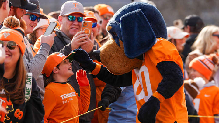 Smokey the mascot plays with a young fan's hat at the Vol Walk before a NCAA football game between Tennessee and Vanderbilt at Neyland Stadium in Knoxville, Tenn., on Nov. 29, 2025. Smokey the mascot plays with a young fan's hat at the Vol Walk before a NCAA football game between Tennessee and Vanderbilt at Neyland Stadium in Knoxville, Tenn., on Nov. 29, 2025.