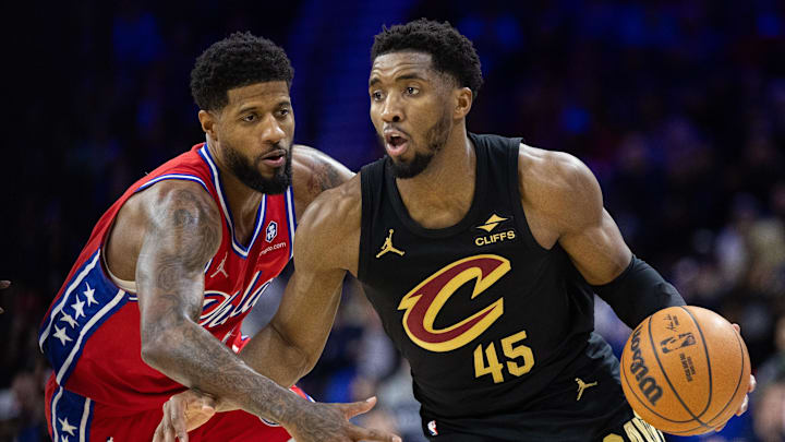 Jan 24, 2025; Philadelphia, Pennsylvania, USA; Cleveland Cavaliers guard Donovan Mitchell (45) dribbles against Philadelphia 76ers forward Paul George (8) during the third quarter at Wells Fargo Center.