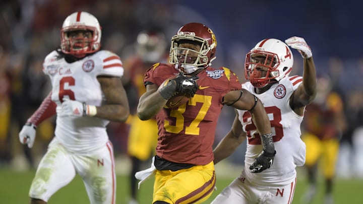 Dec 27, 2014; San Diego, CA, USA; Southern California Trojans tailback Javorius Allen (37) is pursued by Nebraska Cornhuskers linebacker Austin Williams (24) on a 44-yard touchdown run in the third quarter in the 2014 Holiday Bowl at Qualcomm Stadium. Mandatory Credit: Kirby Lee-Imagn Images

