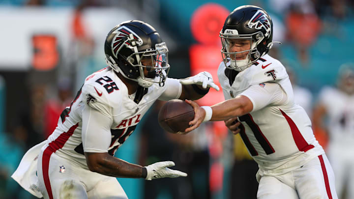 Aug 11, 2023; Miami Gardens, Florida, USA;  Atlanta Falcons quarterback Logan Woodside (11) hands off to running back Carlos Washington Jr. (28) against the Miami Dolphins in the first quarter at Hard Rock Stadium. Mandatory Credit: Nathan Ray Seebeck-Imagn Images