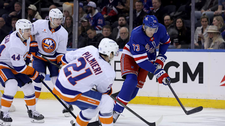 Mar 3, 2025; New York, New York, USA; New York Rangers center Matt Rempe (73) fights for the puck against New York Islanders centers Kyle Palmieri (21) and Jean-Gabriel Pageau (44) and defenseman Alexander Romanov (28) during the third period at Madison Square Garden. Mandatory Credit: Brad Penner-Imagn Images