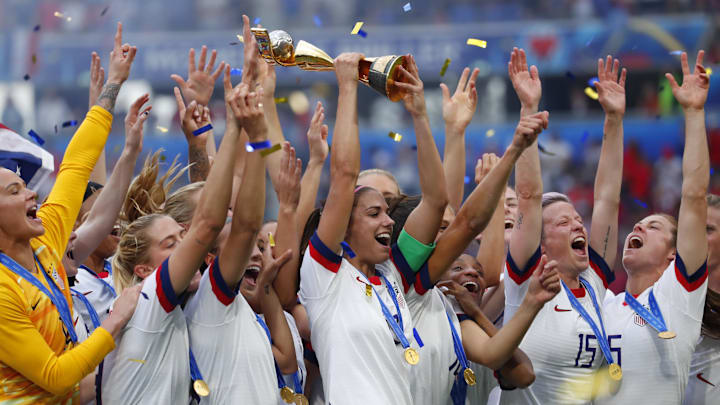 United States forward Alex Morgan (13) hoists the World Cup trophy.