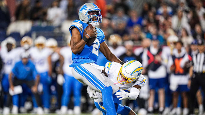 Detroit Lions quarterback Hendon Hooker is tackled by LA Chargers cornerback Nikko Reed.