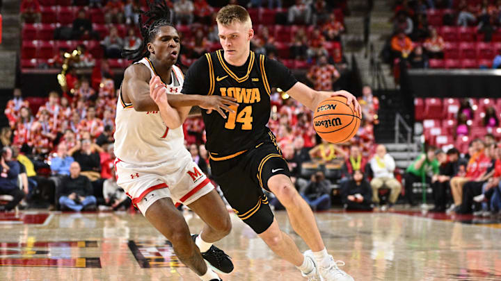 Feb 11, 2026; College Park, Maryland, USA;  Iowa Hawkeyes guard Bennett Stirtz (#14) controls the ball while being defended by Maryland Terrapins guard Andre Mills (7) in the first half at Xfinity Center. Mandatory Credit: Jamie Sabau-Imagn Images