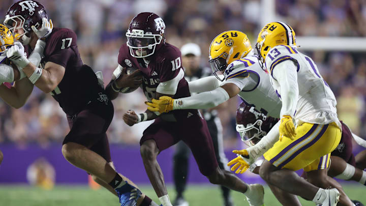 Oct 25, 2025; Baton Rouge, Louisiana, USA; Texas A&M Aggies quarterback Marcel Reed (10) scrambles against Louisiana State Tigers defensive end Jimari Butler (12) during the second half at Tiger Stadium. Mandatory Credit: Stephen Lew-Imagn Images Oct 25, 2025; Baton Rouge, Louisiana, USA; Texas A&M Aggies quarterback Marcel Reed (10) scrambles against Louisiana State Tigers defensive end Jimari Butler (12) during the second half at Tiger Stadium. Mandatory Credit: Stephen Lew-Imagn Images