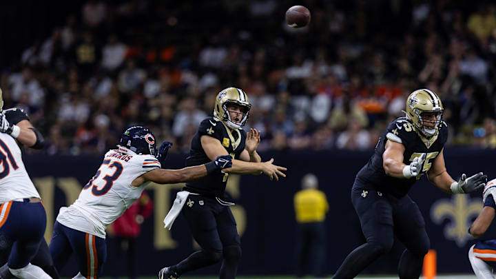 Derek Carr, eluding the rush of T.J. Edwards to get off a pass, has a shoulder injury that might impact who the Bears draft.