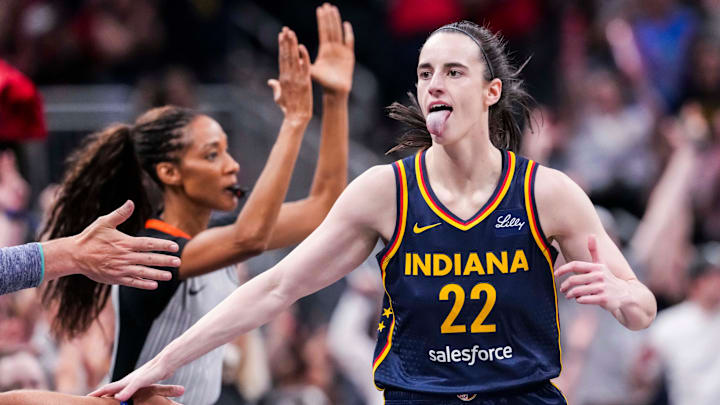 Indiana Fever guard Caitlin Clark (22) high-fives fans after scoring a 3-pointer Saturday, June 14, 2025, during a game between the Indiana Fever and the New York Liberty at Gainbridge Fieldhouse in Indianapolis.